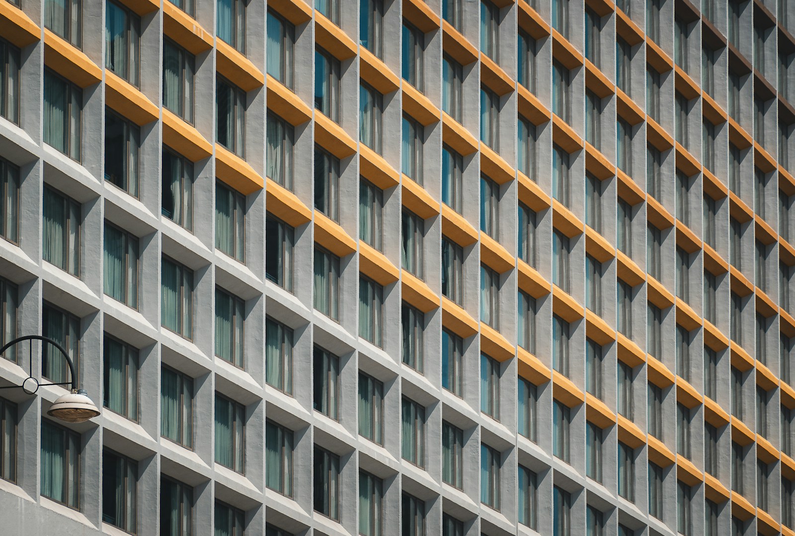 Modern building facade with repeating windows and yellow accents